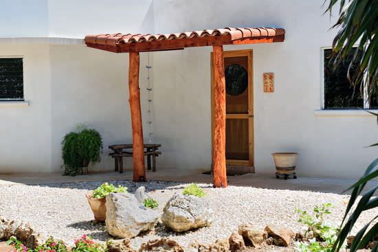 Door awning with clay tile roof and rustic wooden posts
