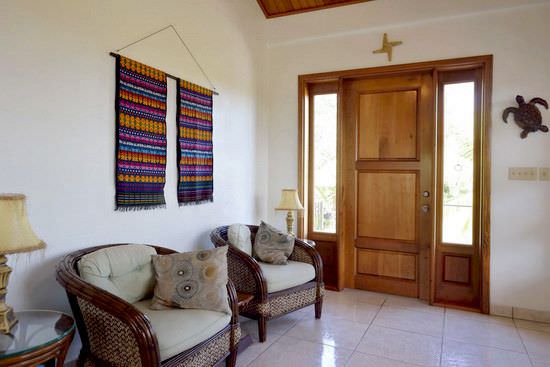 Living room with rotan furniture and mahogany entrance door